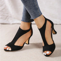 Black suede T-strap heels with open toe and ankle strap.