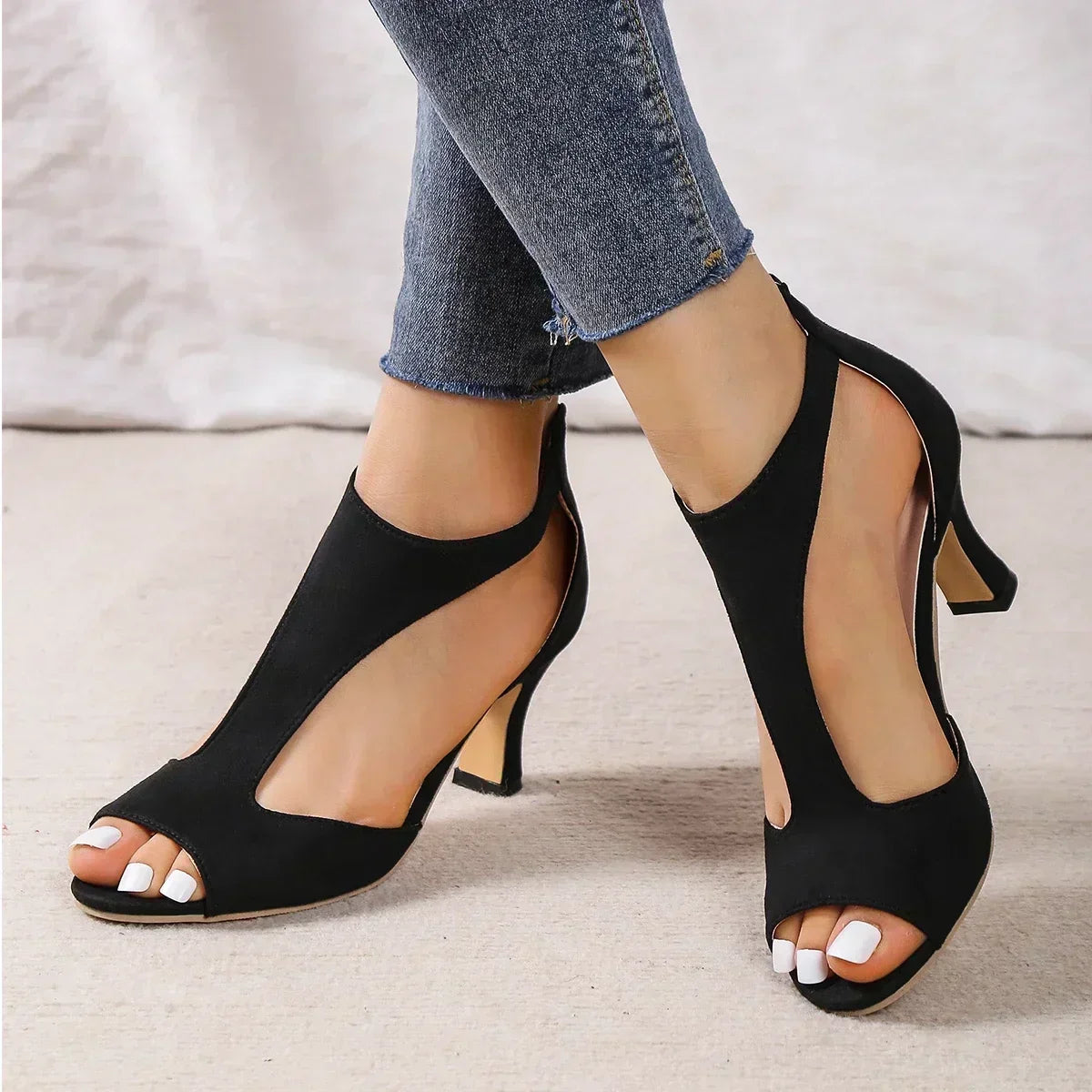 Black suede T-strap heels with open toe and ankle strap.