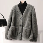 Gray fluffy cardigan on a mannequin with a black handbag in the background