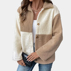 Woman wearing a beige and white sherpa jacket against a gray background