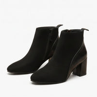 Black suede boots on a white background