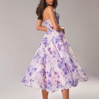 Woman wearing a floral dress with a plain background